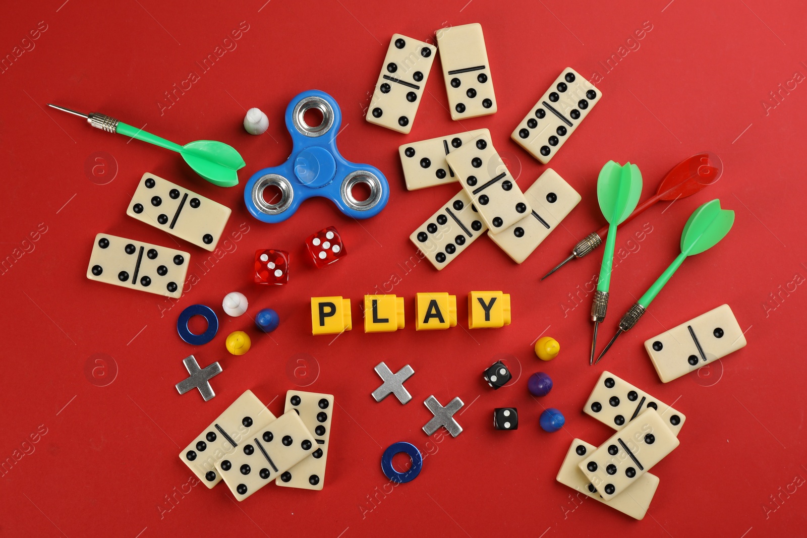 Photo of Components of board games and blocks with word Play on red background, flat lay