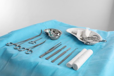Photo of Different surgical instruments on table against light background