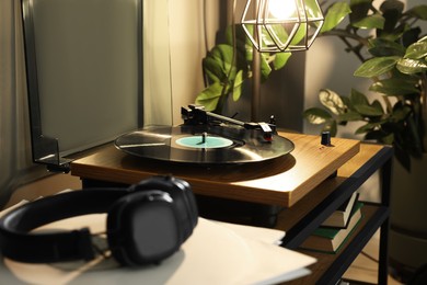 Stylish turntable with vinyl record on table indoors