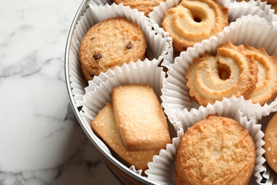 Photo of Tin box with Danish butter cookies on marble table, closeup. Space for text