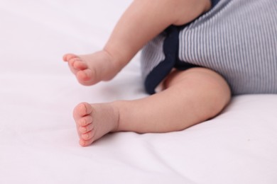 Photo of Newborn baby lying on white blanket, closeup