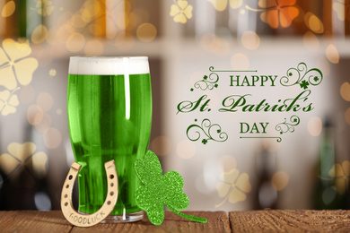 Image of Green beer, horseshoe and clover on wooden counter. St.Patrick's Day celebration