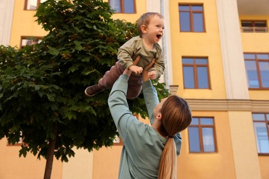 Nanny with cute little boy having fun outdoors