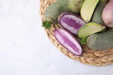 Photo of Green and purple daikon radishes on white table, top view. Space for text