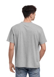 Young man wearing grey t-shirt on white background, back view