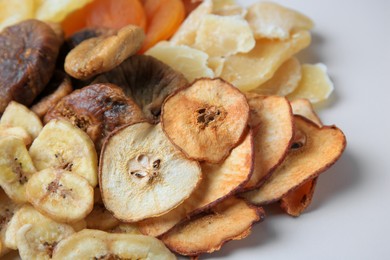 Pile of different dried fruits on white background, closeup