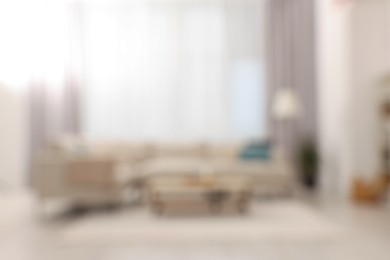 Photo of Blurred view of stylish living room interior with cozy sofa