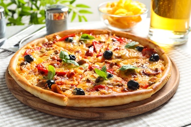 Photo of Delicious pizza with olives and sausages on table