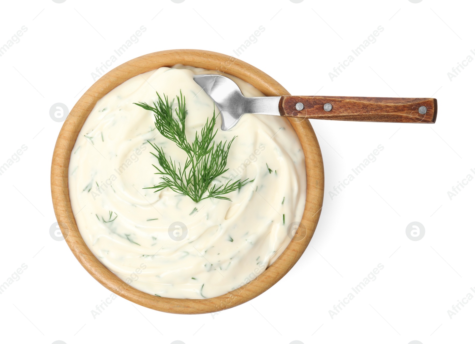 Photo of Tasty creamy dill sauce in bowl with spoon isolated on white, top view