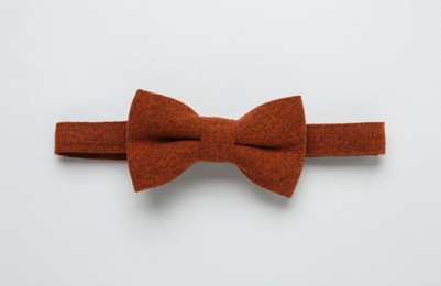 Stylish terracotta bow tie on white background, top view