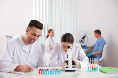 Photo of Medical students with microscope in modern laboratory