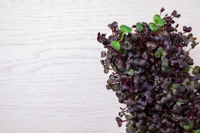 Photo of Fresh organic microgreen on white wooden table, top view. Space for text