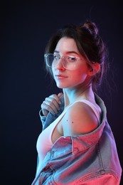 Photo of Portrait of beautiful young woman in glasses on color background