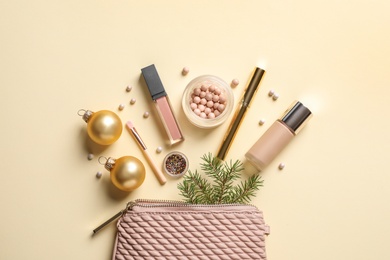 Flat lay composition with makeup products and Christmas decor on color background