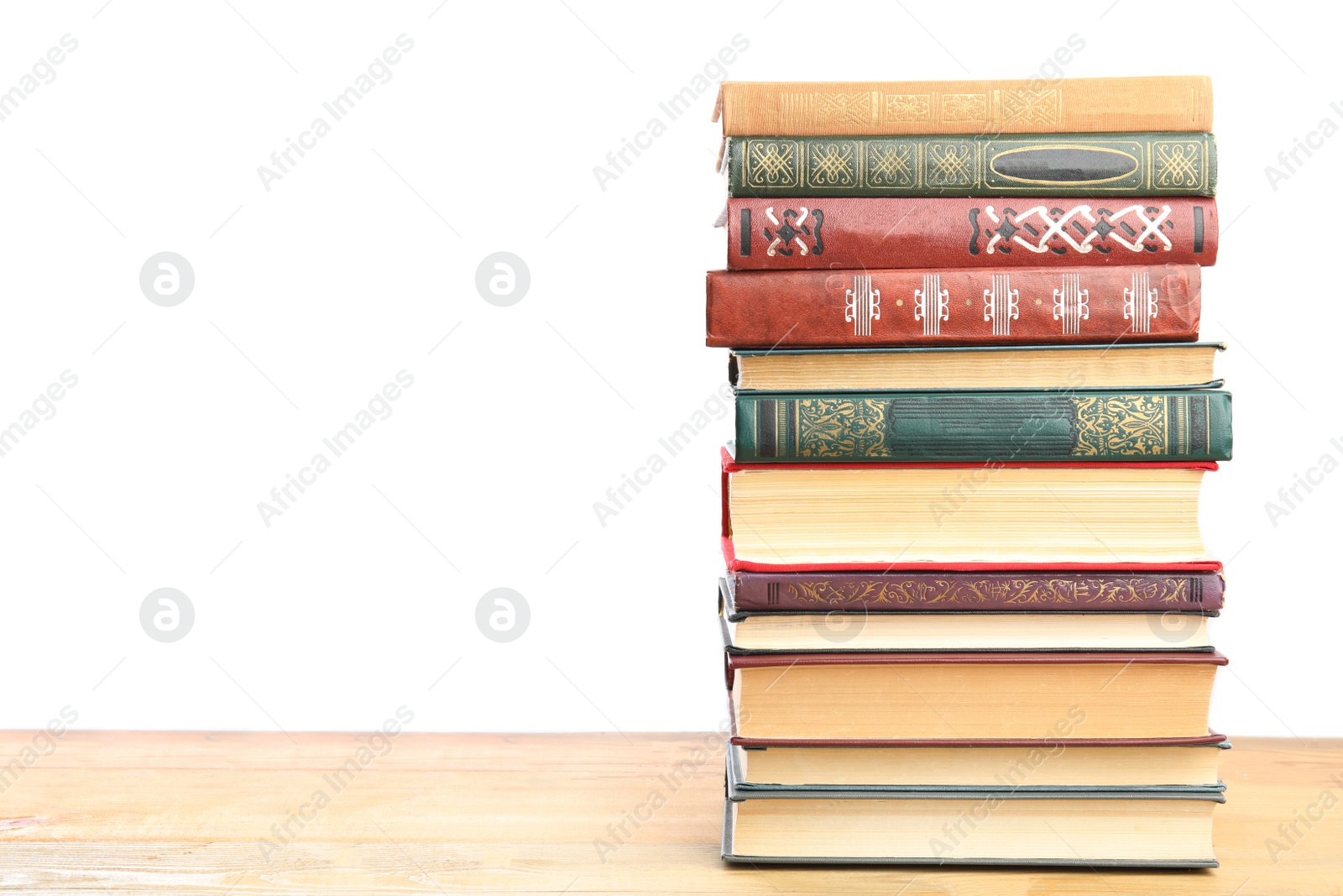 Photo of Stack of old vintage books on wooden table against white background