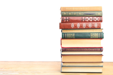 Photo of Stack of old vintage books on wooden table against white background