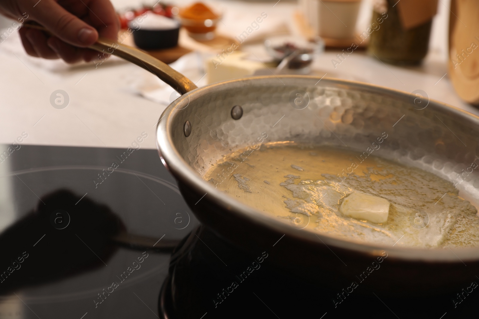 Photo of Frying pan with melted butter on stove, closeup