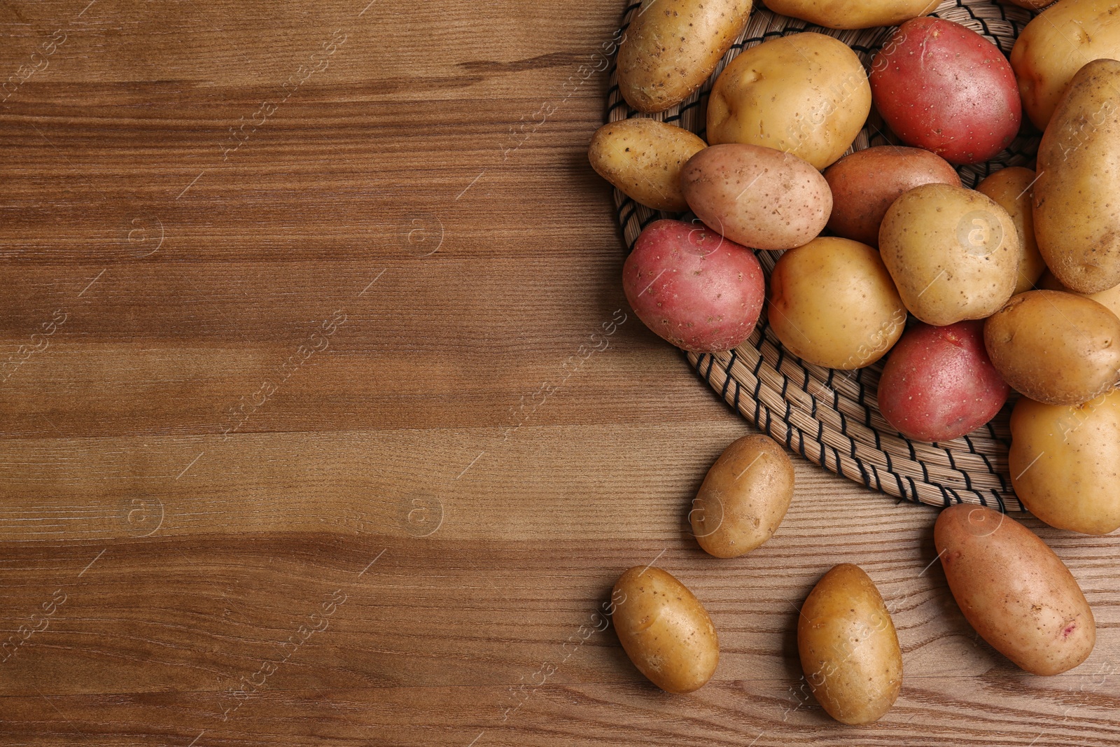 Photo of Flat lay composition with fresh organic potatoes on wooden background