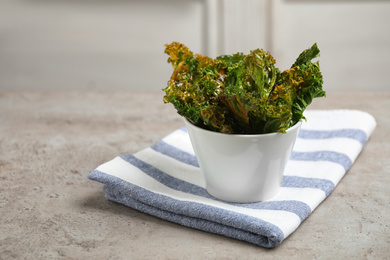 Photo of Tasty baked kale chips on grey table