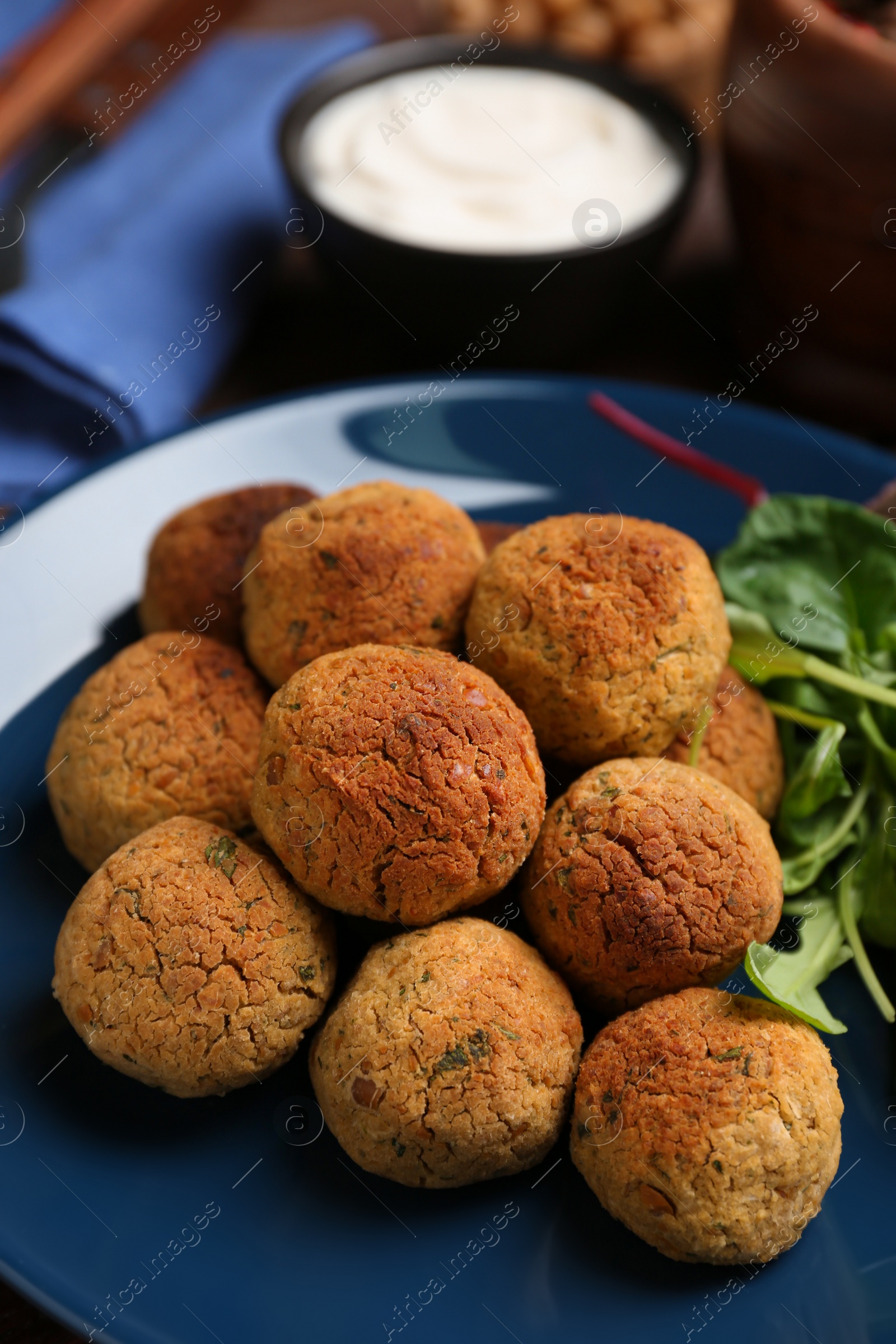 Photo of Delicious falafel balls with herbs on plate, closeup