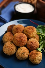 Delicious falafel balls with herbs on plate, closeup