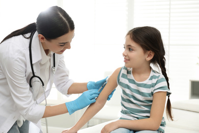 Photo of Doctor vaccinating little child in modern clinic