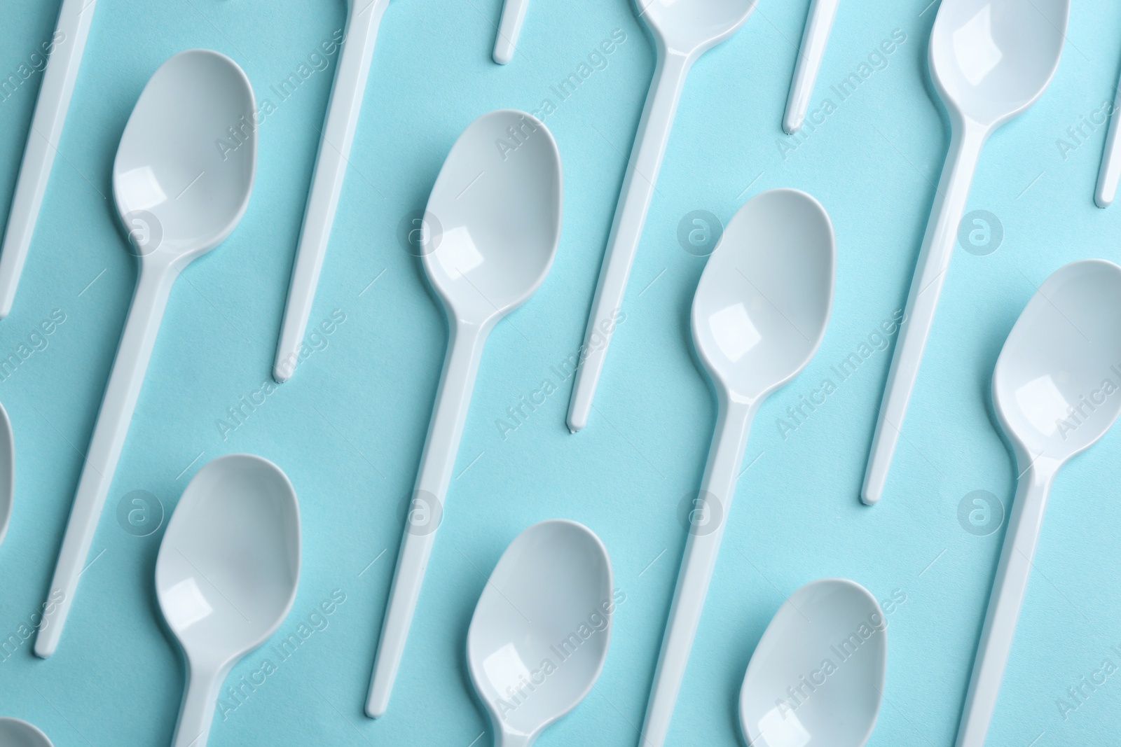 Photo of Flat lay composition with plastic spoons on color background. Table setting