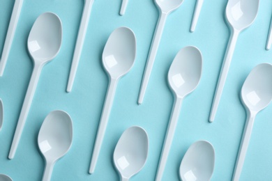 Photo of Flat lay composition with plastic spoons on color background. Table setting