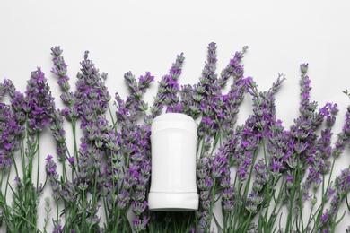 Photo of Female deodorant and lavender flowers on white background, top view