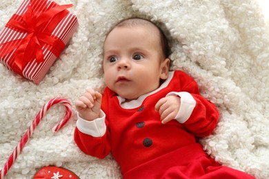 Photo of Cute little baby on soft blanket with Christmas decorations, top view