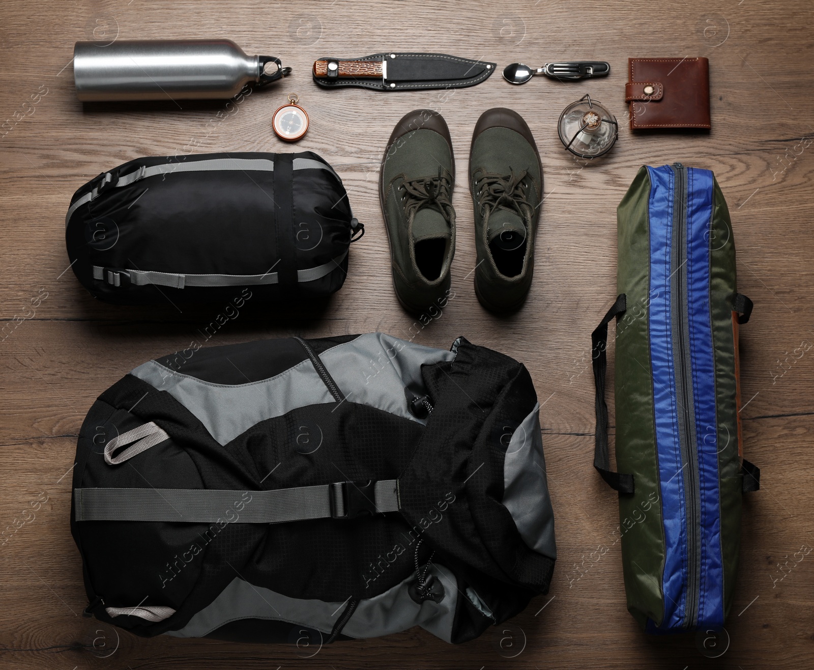 Flat lay composition with different camping equipment on wooden background Photo of Flat lay composition with different camping equipment on wooden background