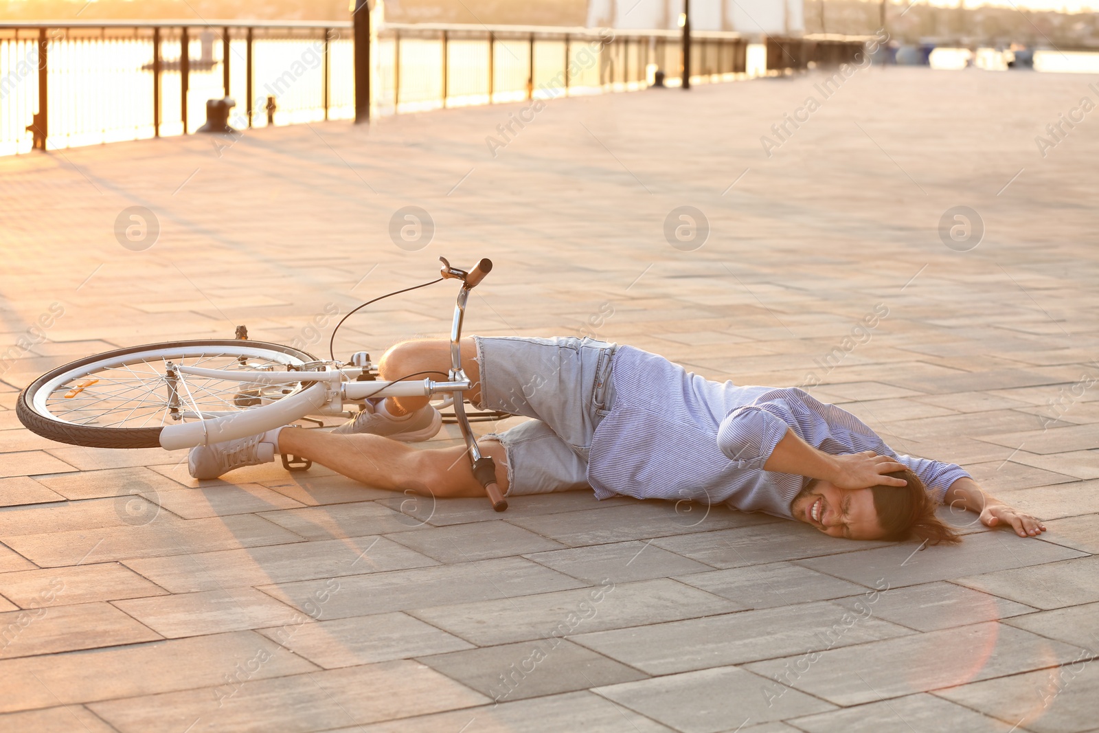 Photo of Man fallen off his bicycle on street