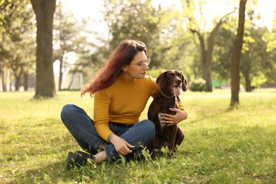 Woman with her cute German Shorthaired Pointer dog in park on spring day