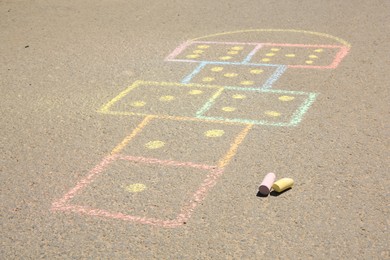 Hopscotch drawn with colorful chalk on asphalt outdoors, closeup