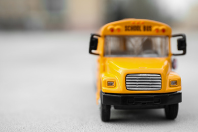 Photo of Closeup view of yellow toy school bus outdoors, space for text. Transport for students