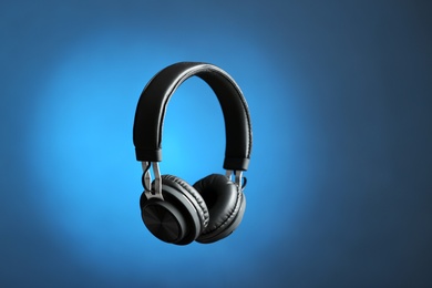 Photo of Stylish headphones on color background. Space for text