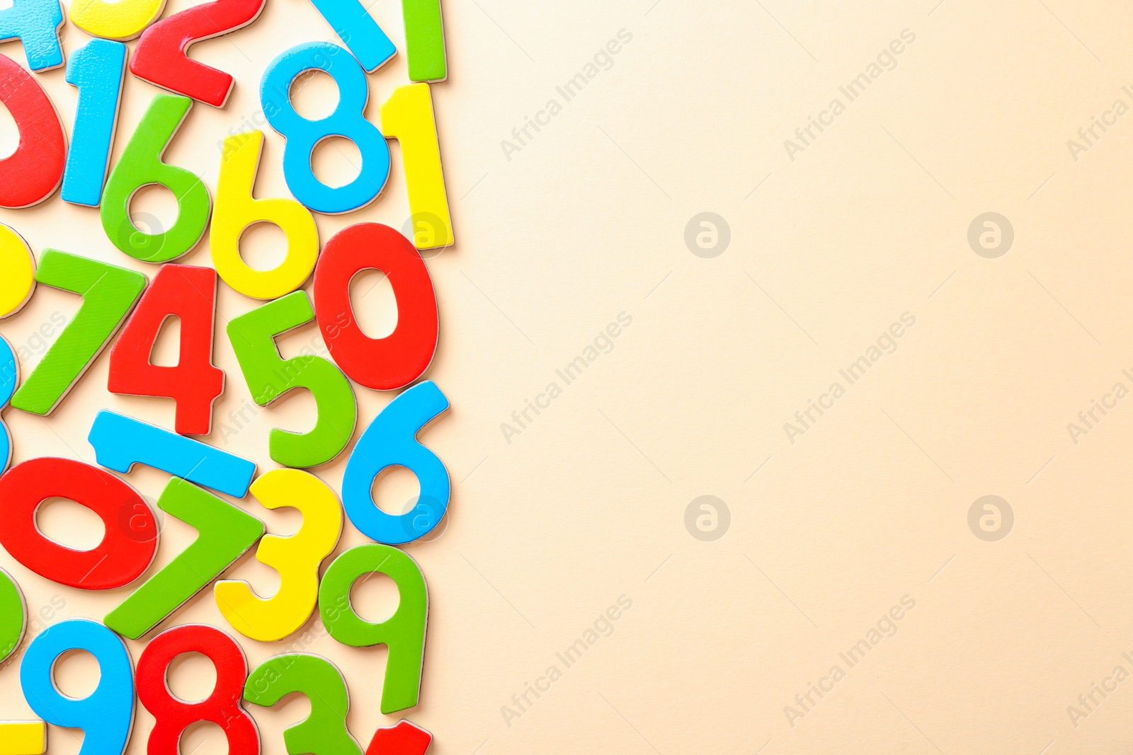 Photo of Colorful numbers on beige background, flat lay. Space for text