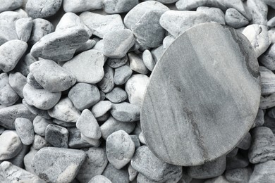 Photo of Presentation for product. Stone podium on grey pebbles, top view