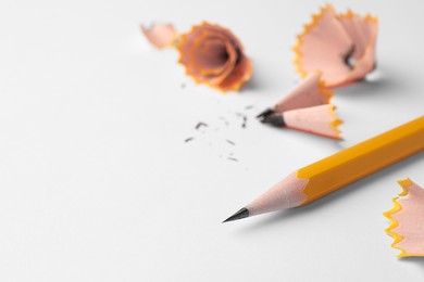 Photo of Graphite pencil and shavings on white background, closeup. Space for text