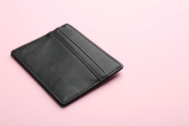 Photo of Empty leather card holder on pink background