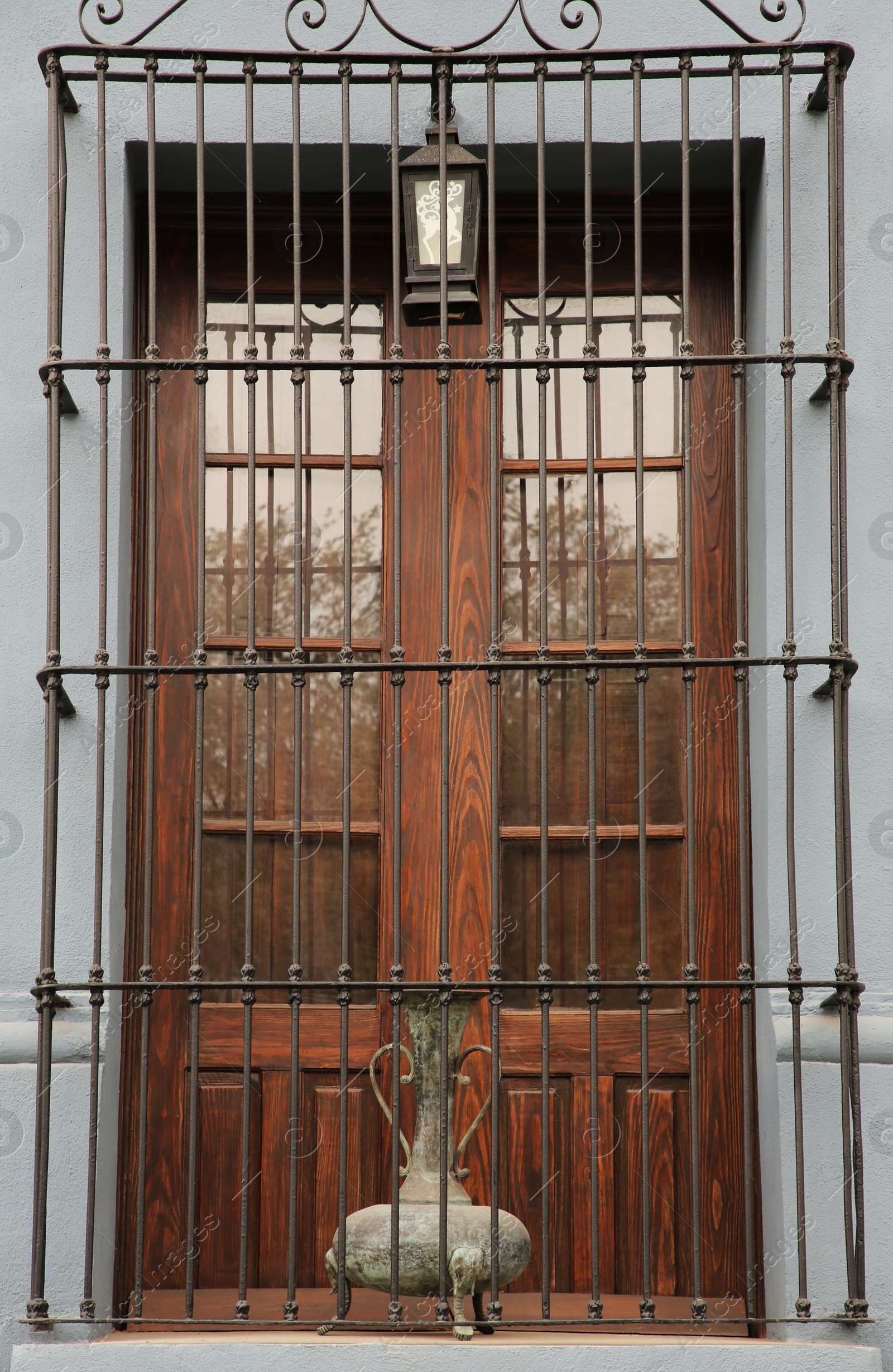 Photo of Building with wooden window and steel grilles outdoors