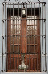 Photo of Building with wooden window and steel grilles outdoors