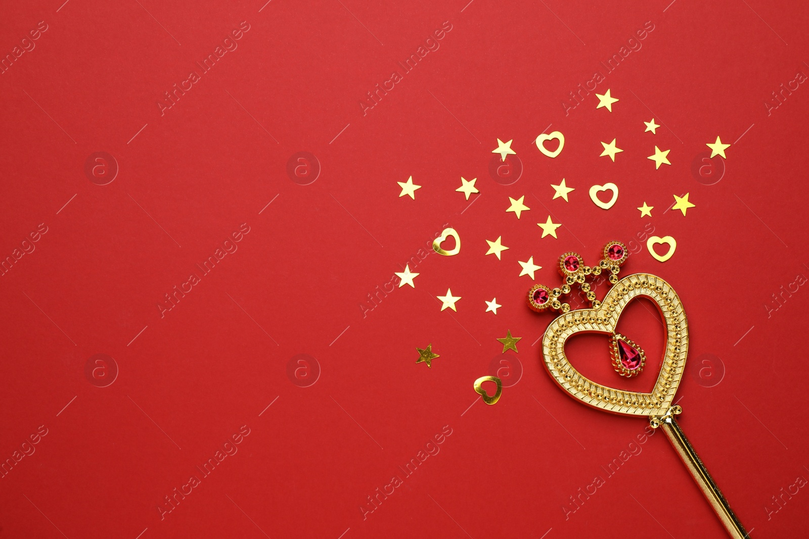 Photo of Beautiful golden magic wand and confetti on red background, flat lay. Space for text