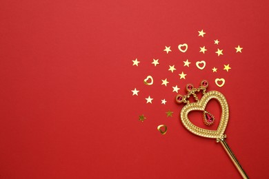 Photo of Beautiful golden magic wand and confetti on red background, flat lay. Space for text