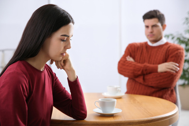 Photo of Unhappy woman after quarrel with her boyfriend in cafe. Relationship problems