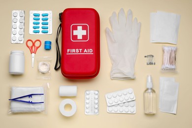 Photo of Flat lay composition with first aid kit on beige background
