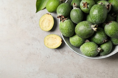 Flat lay composition with fresh green feijoa fruits on light grey table. Space for text