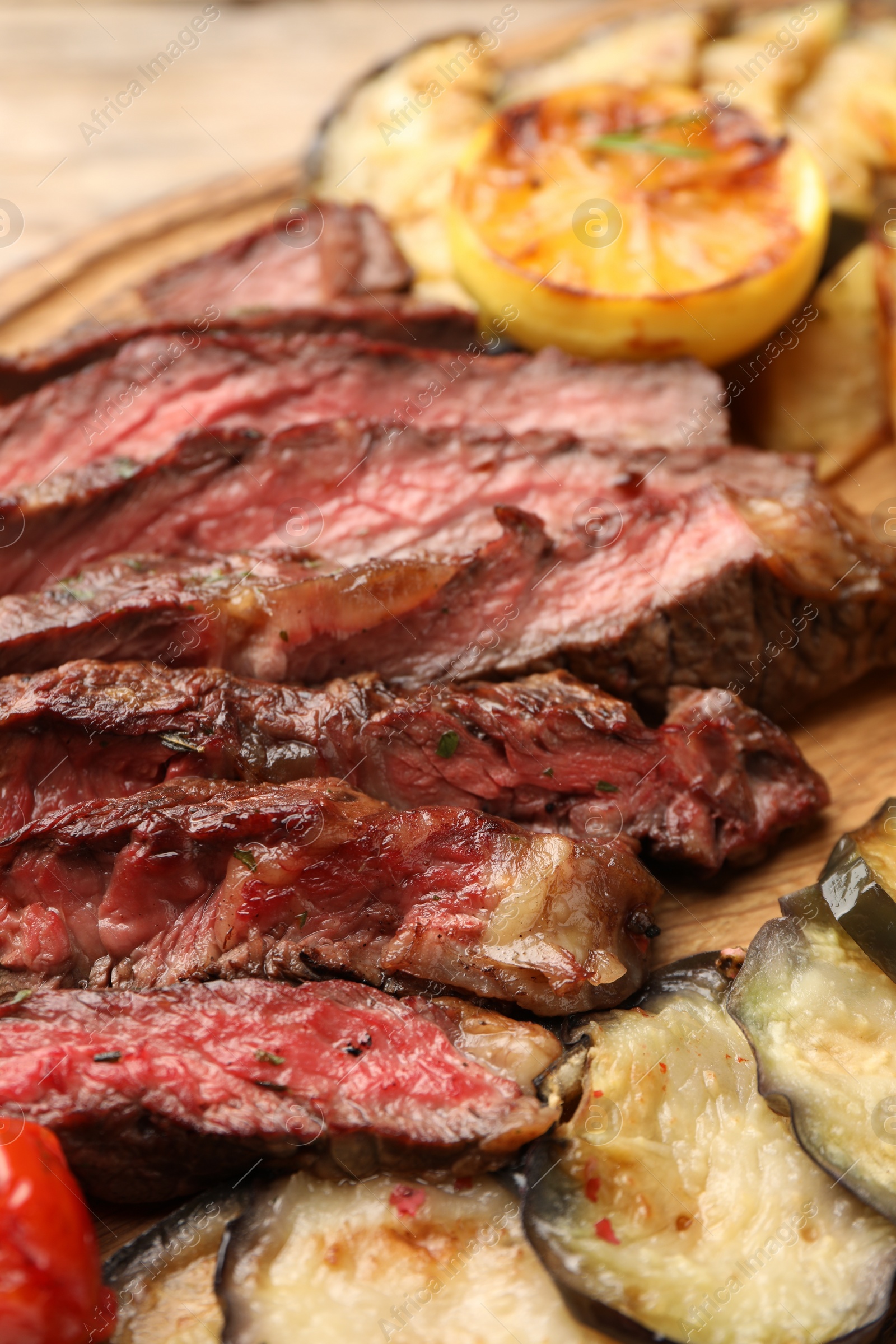 Photo of Delicious grilled beef with vegetables on table, closeup