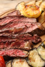 Photo of Delicious grilled beef with vegetables on table, closeup