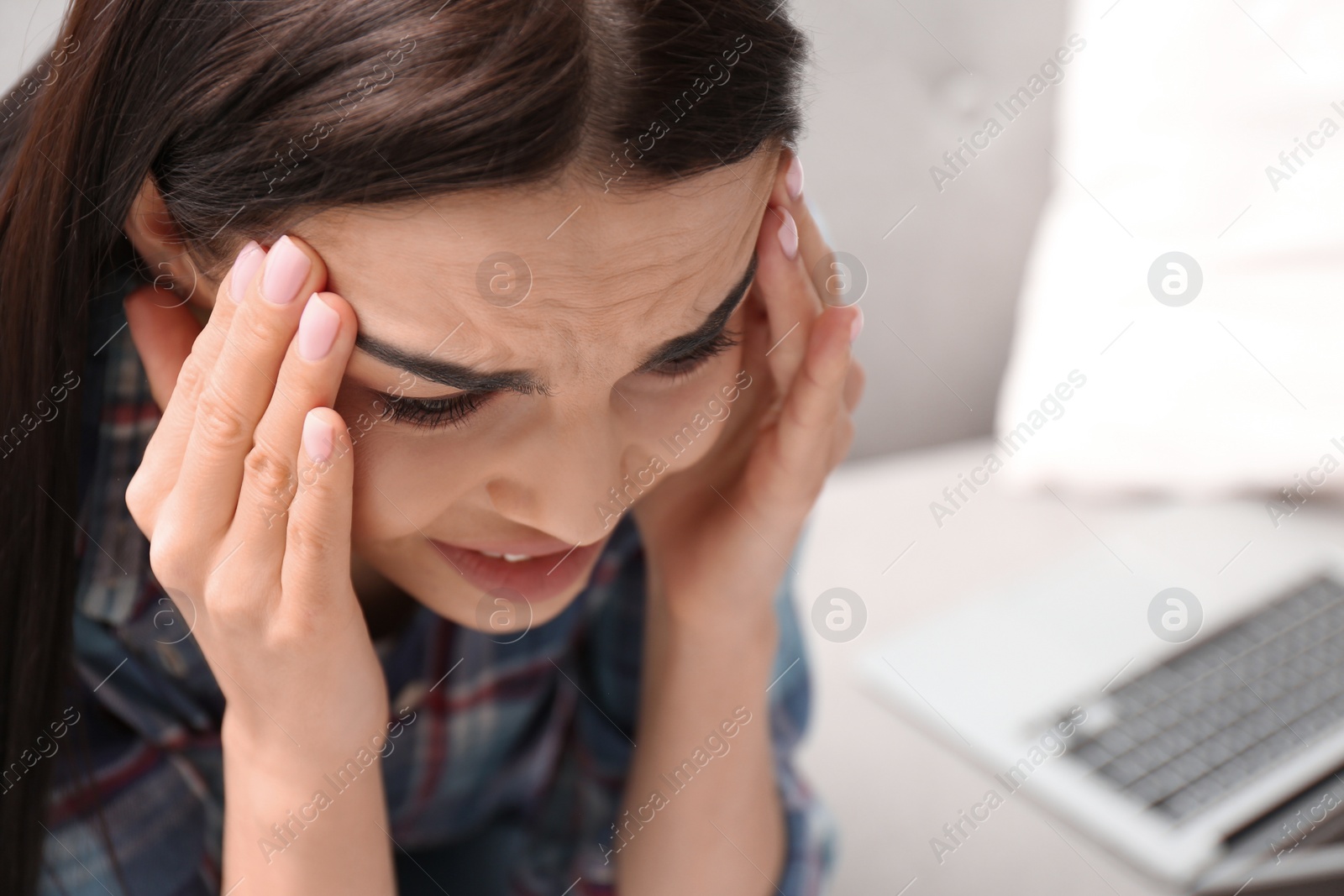 Photo of Young woman suffering from migraine at home, closeup. Space for text